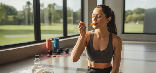 Young woman taking a spoonful of Manuka honey in a fitness studio. 